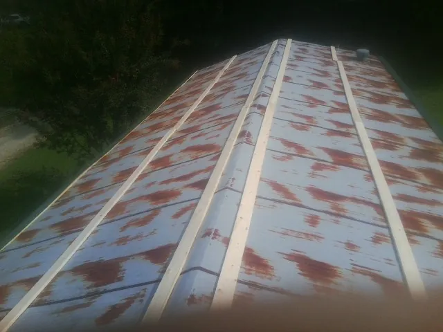 Rusted metal roof panels with new wood purlins before replacement — Storm Damage Roof Repair in Purdys by Roofing Brothers