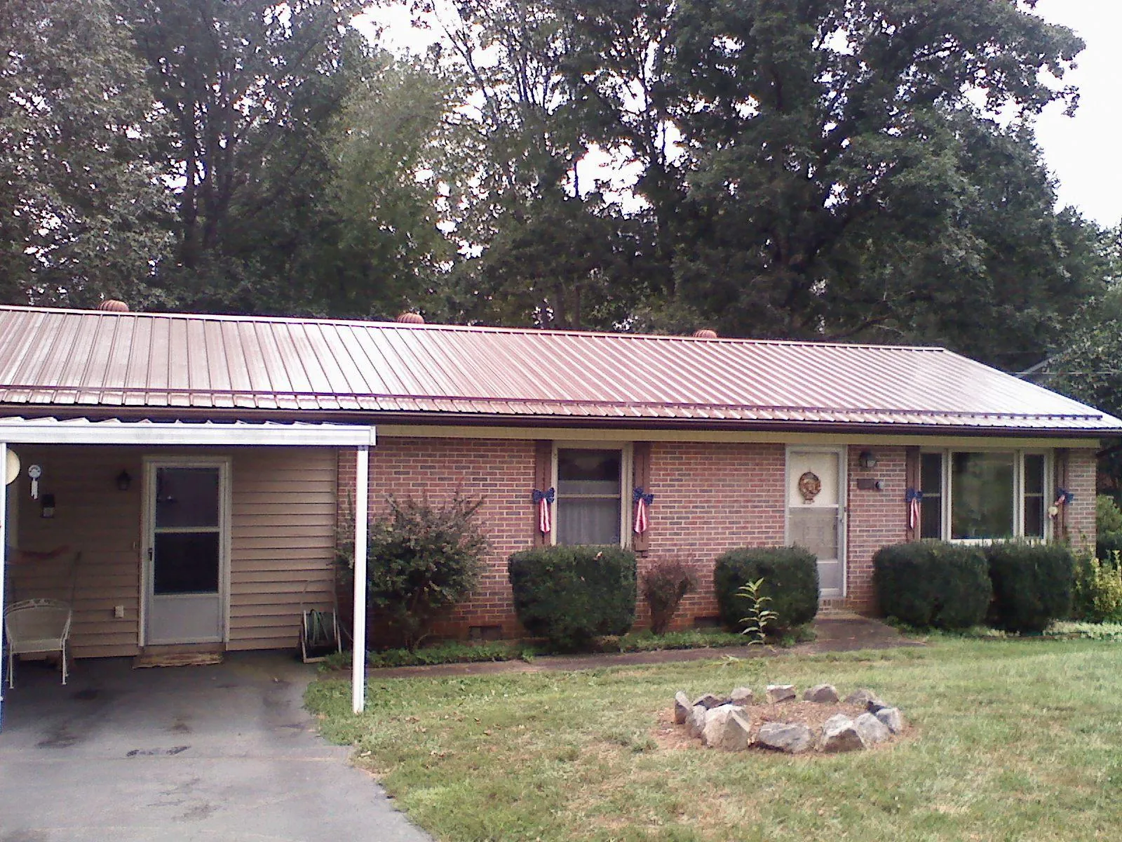 Bronze metal roof and carport on a brick ranch home — Roof Repair work by our crew in Purdys